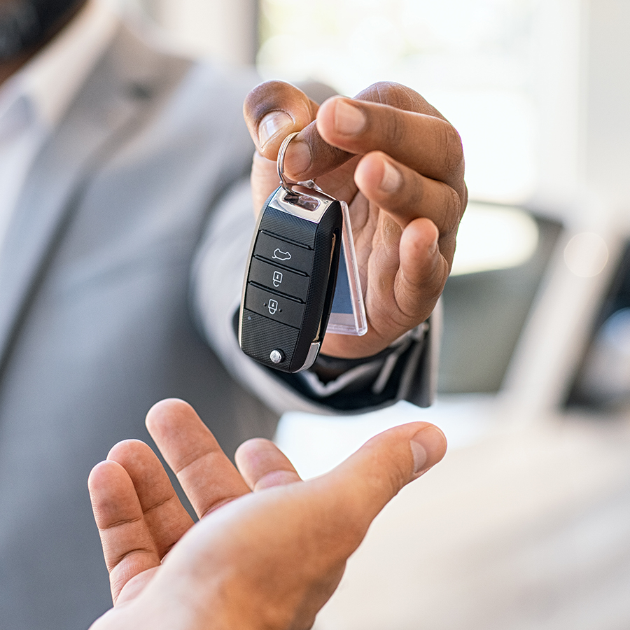 Dealership employee handing keys to customer.