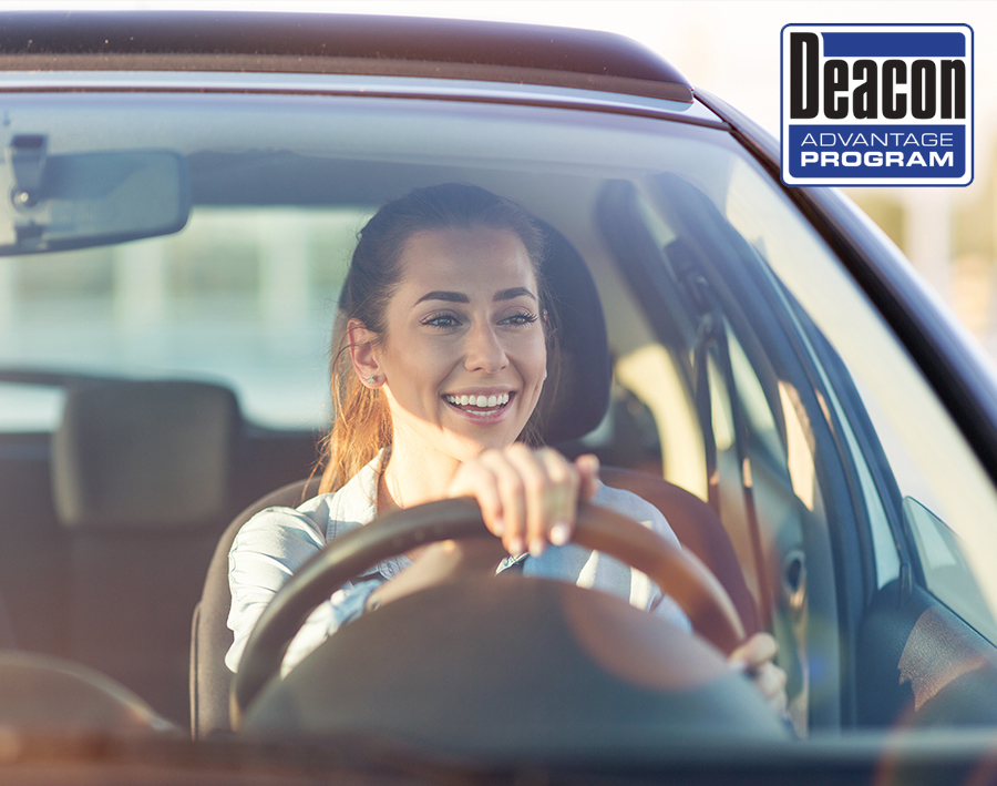 Happy woman driving a car and smiling