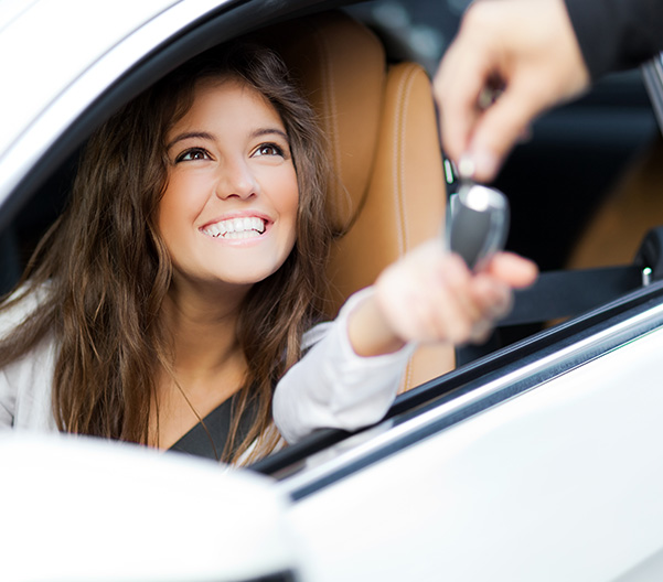 Happy woman being handed car keys