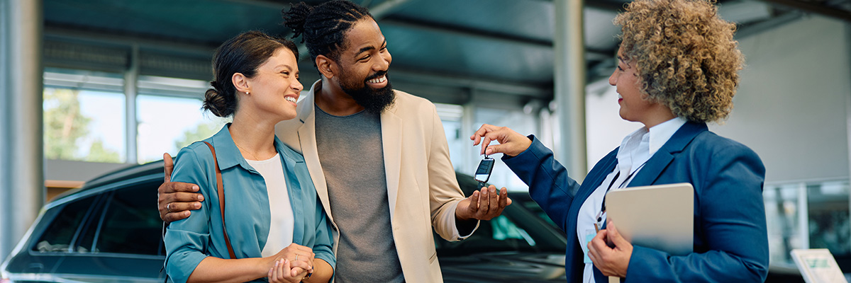 Happy customers with car sales associate