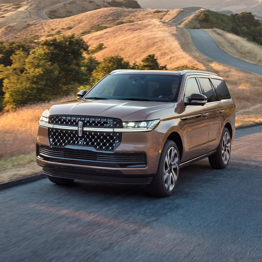 A 2026 Lincoln Black Label Navigator® SUV is being driven on a rural road