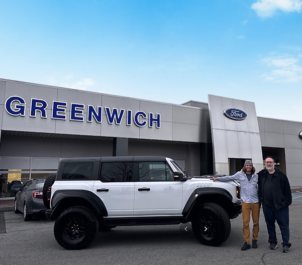Happy customers standing infront of dealership