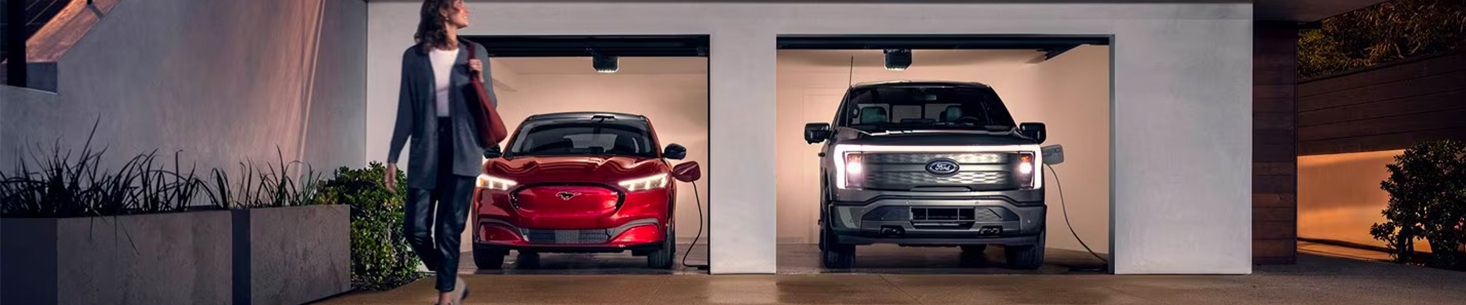 Woman walking into her house with two fords charging in her garage