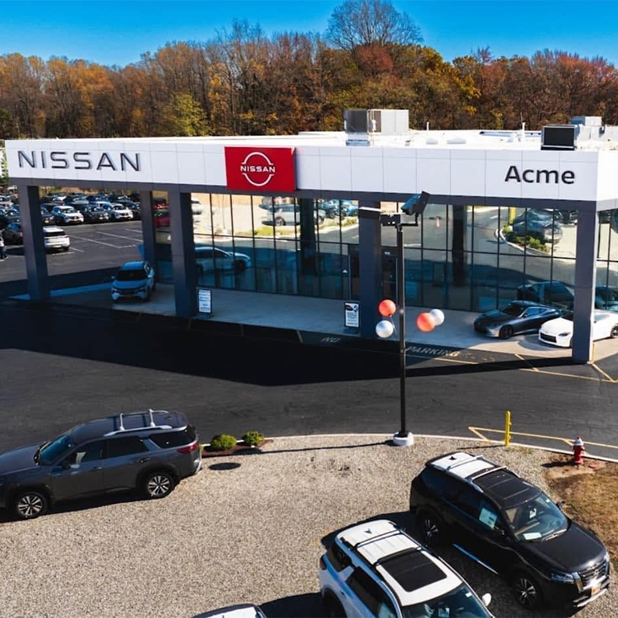Dealership employee smiling shaking hands with satisfied customer.