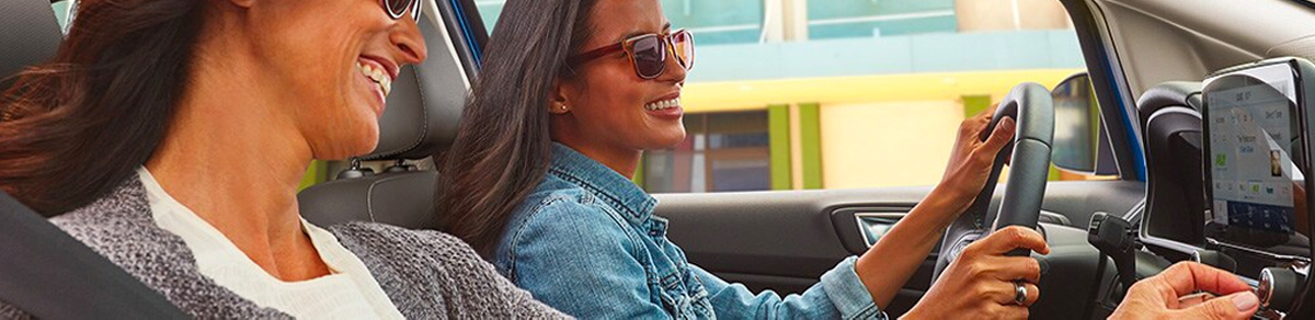 Side view of female driver and female passenger in 2020 Ford EcoSport under open sunroof