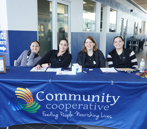 Four women seated at charity event booth.