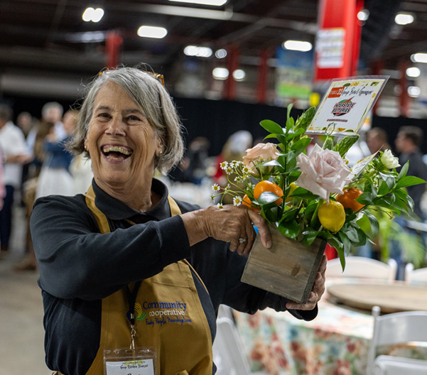 Joyful woman presenting a flower arrangement.