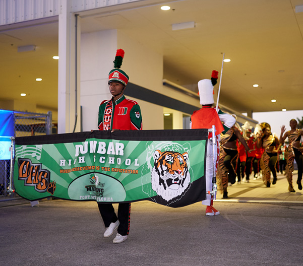 Band member holding Dunbar High School banner