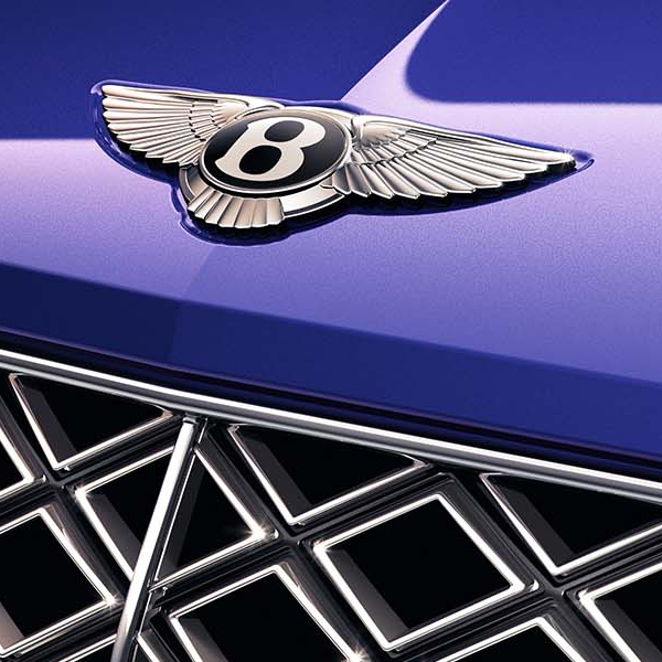 Close up shot of the Bentley badge on hood of vehicle