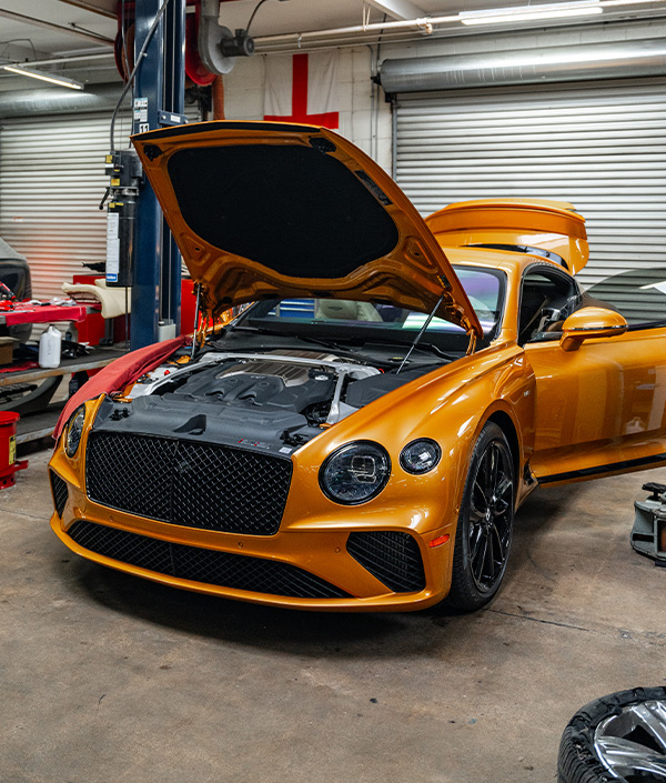 3/4 front shot of a Bentley being serviced