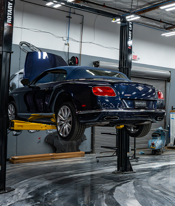 Rear shot of Bentley being serviced on lift