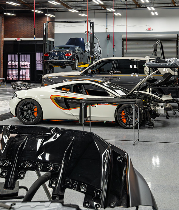 Side shot of McLaren being worked on in service floor