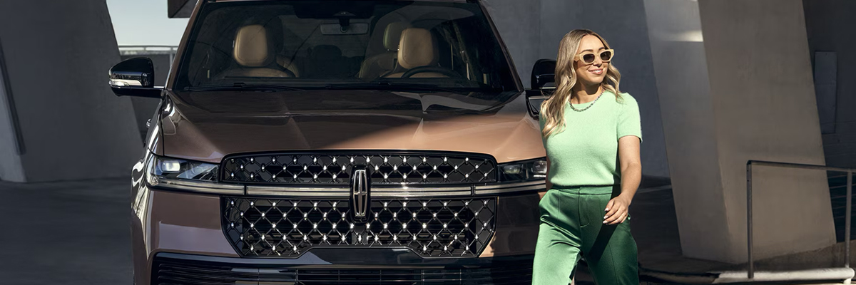 Woman walking in front of her Lincoln vehicle