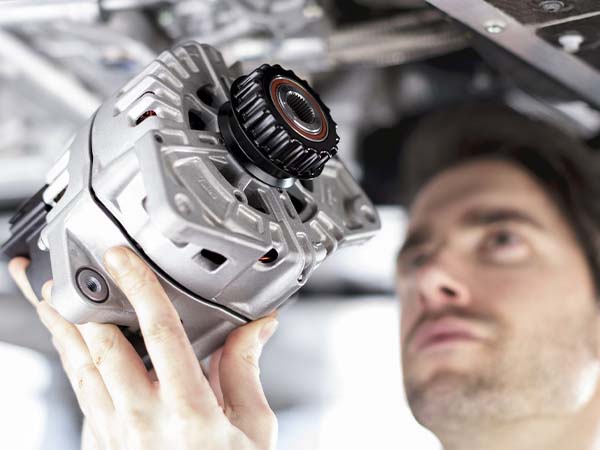 Service tech holding up a McLaren part