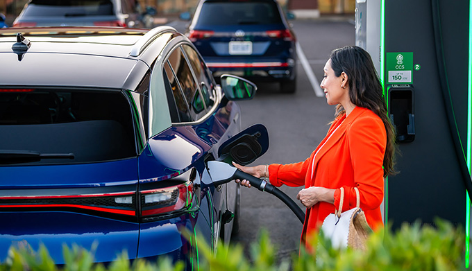 Woman charging Volkswagen ID.4 at a station