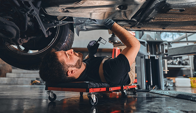 Technician working underneath car