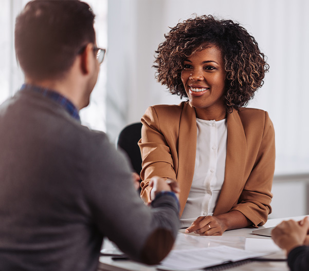 Businesswoman shaking hands smiling with businessman