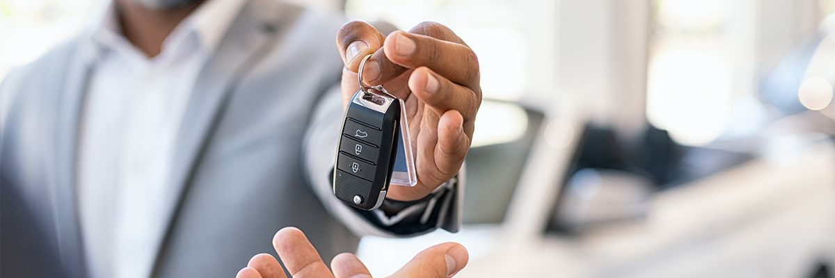 Up close shot of dealership handing customer keys