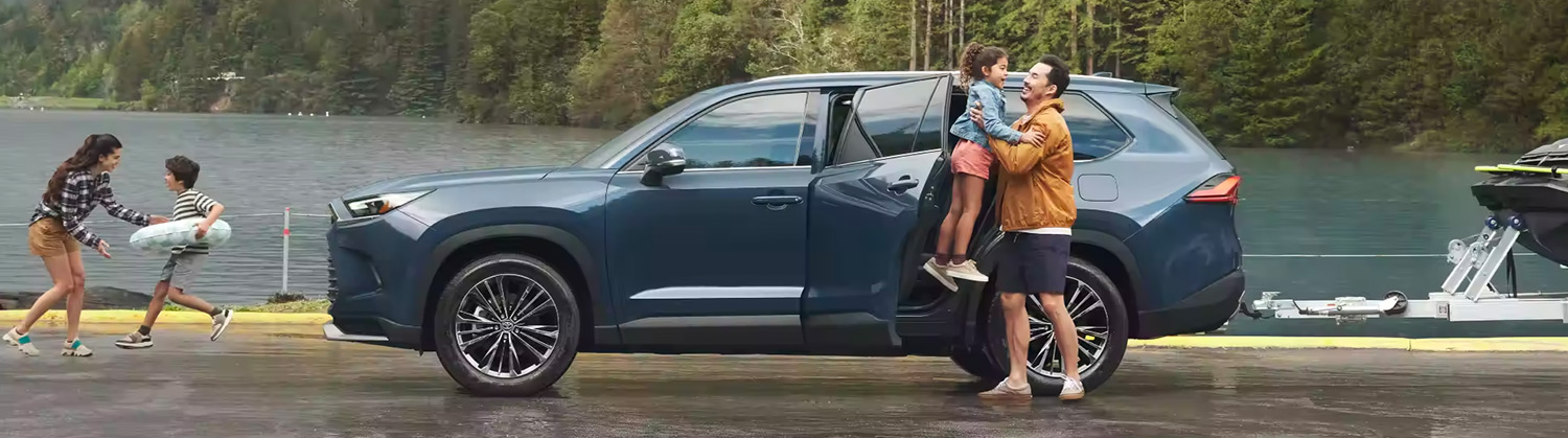 Side view of Grand Highlander with family around it