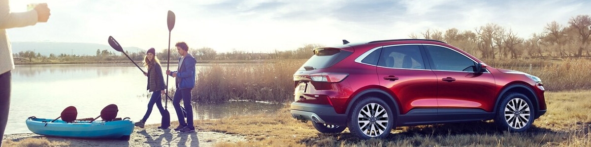 Ford Escape parked by river with Kayakers