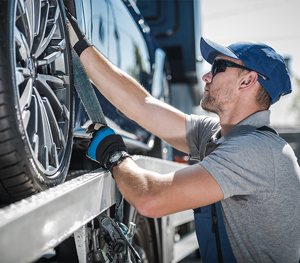 Closeup shot of car being loaded onto truck to be towed.
