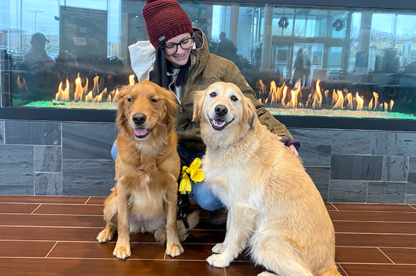 happy dealership employee with dogs in front of fire