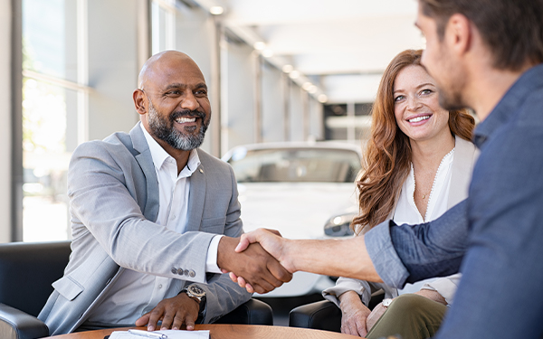 Couple buying new car at car dealership