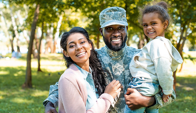 Military family hugging in park