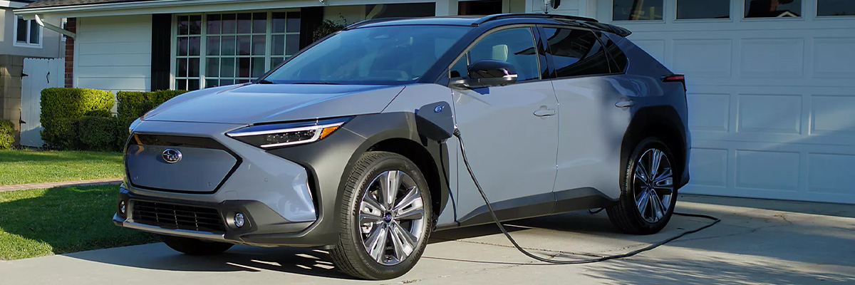 Subaru plugged up charging in front of a house