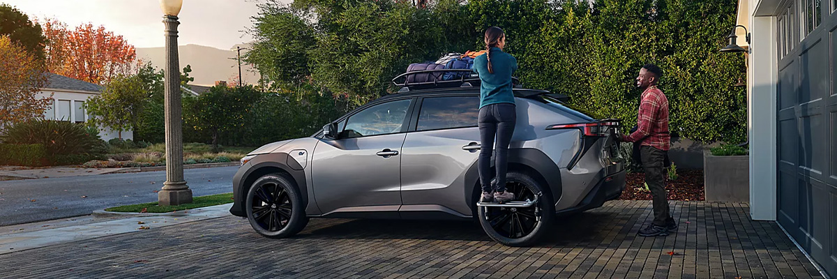 Happy couple loading up their Solterra EV in front of their house