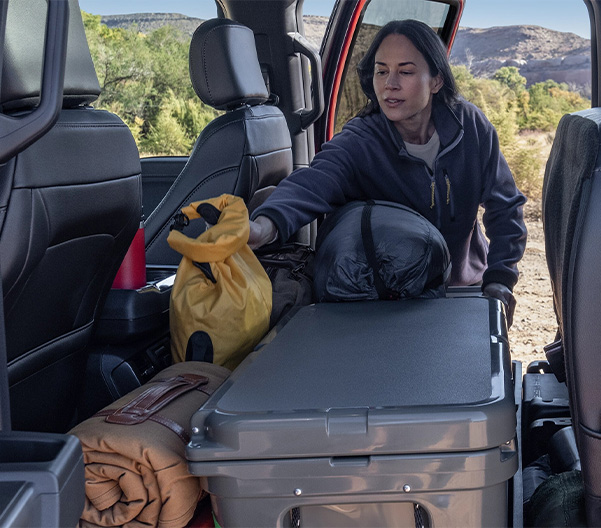 Woman packing up the rear of a vehicle for her roadtrip